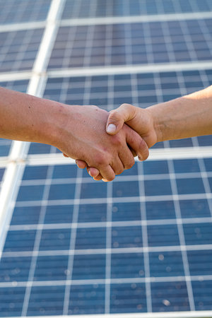 Solar panels with handshakes close up. Agreement about new station installationの写真素材