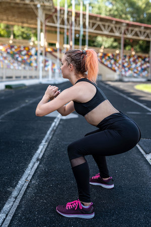 sexy fitness woman make stretching and warming up before hard workout at outdoor, stadiumの写真素材
