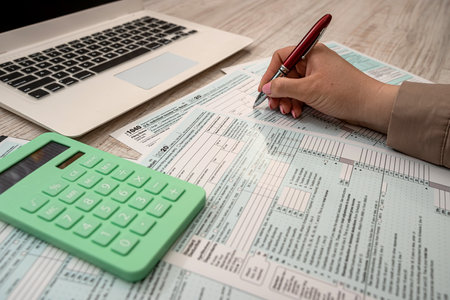 woman work with USA tax form 1040 and calculator laptop at office. Accounting concept
