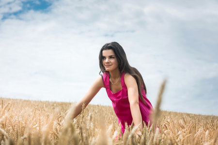woman in dress stands in wheat field. beautiful at nature. Freedomの写真素材