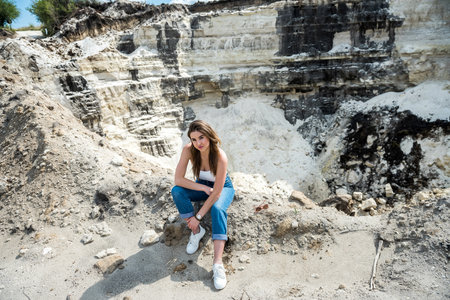 Pretty woman poses against sand canyon background of rocks in hot summer sunny dayの写真素材