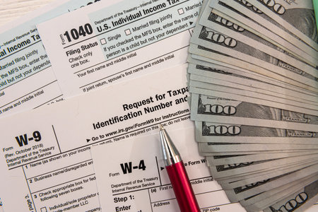 1040 tax form with pen and US dollar bills, financial concept