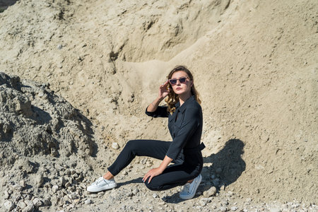 beautiful woman in coveralls posing for the camera in the sand quarry, summertimeの写真素材