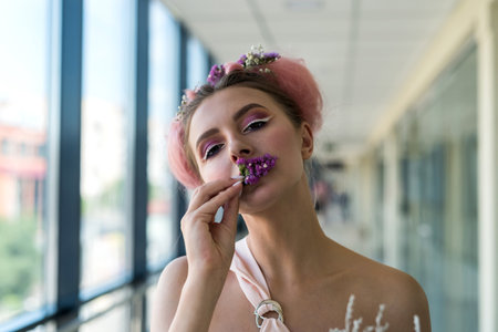 Portrait of attractive woman with hairstyle and makeup near windowの写真素材