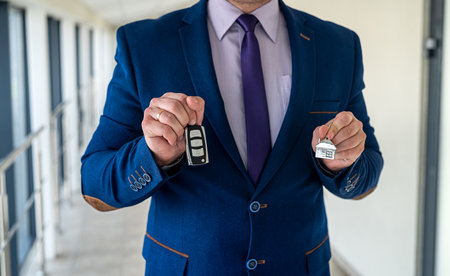 salesman hold house and car key, sale or rent concept. purchase or giftの写真素材