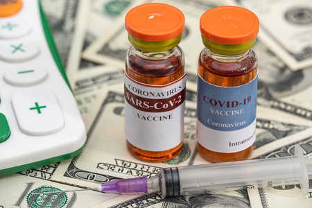 vaccine flasks with syringes lie on dollar bills. vaccination conceptの写真素材