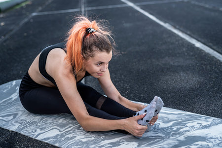 female trainer doing yoga or pilates exercise against green stadium background. Active Lifestyle,...