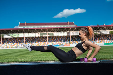 athletic female coach in sportswear doing fitness workout at green stadium. healthy sporty lifestyleの写真素材