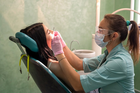 Young woman sitting in dentist chair on doctors reviewの写真素材