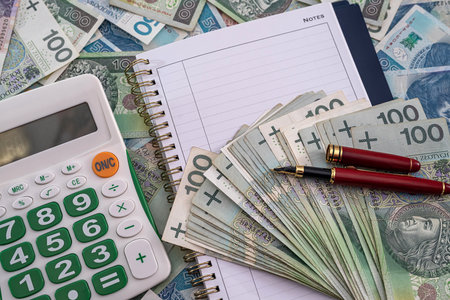 new calculator notebook for business records red pen on the background of pottery zloty banknotes. business conceptの写真素材
