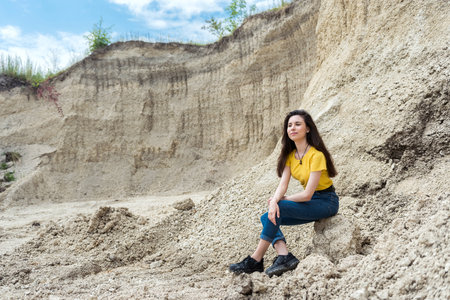 woman posing in background of mountain of sand, summer lifestyle, beauty of natureの写真素材