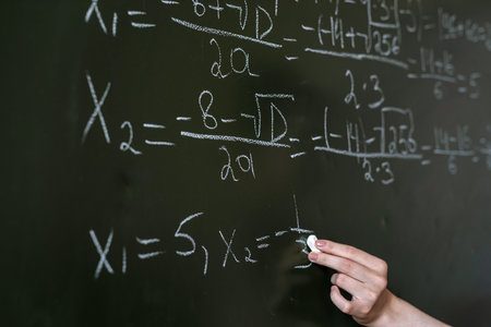 female hand writing math formulas on the classboard, close-upの写真素材