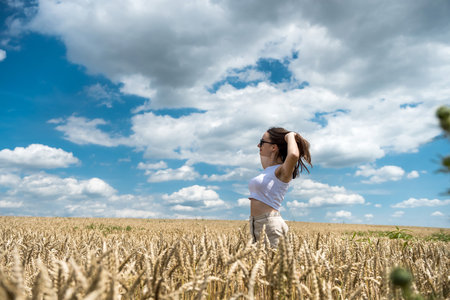 Portrait of charming young woman in golden cereal field, freedomの写真素材