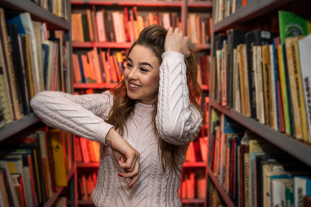 beautiful young teacher with a nice appearance spends her free time reading books in the library. library concept. knowledge conceptの写真素材