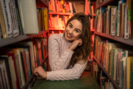 young female student looking for a book in university library