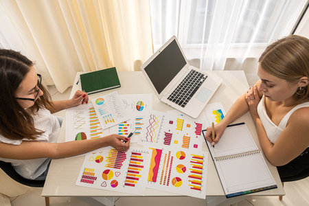 two serious business ladies working on design charts at a spacious table. business concept. Graphic conceptの写真素材