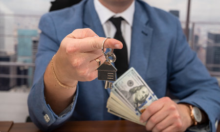 business man in a strict suit with dollars in his hands signs an important business contract. business and contract conceptの写真素材