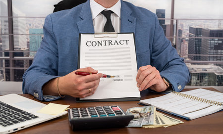 handsome elegant man in clothes with dollars in his hands signed a wonderful contract and he was paid. Dollars and contract business conceptの写真素材