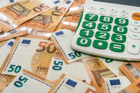 new blank calculator with green buttons lies on new euro banknotes. business conceptの写真素材