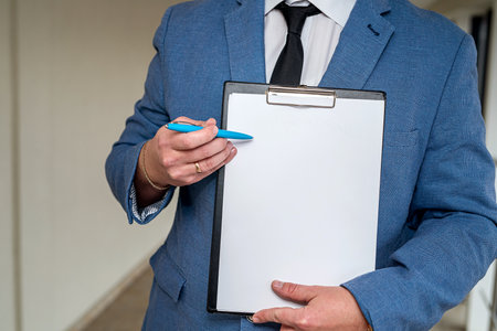 stylish young businessman in a classic suit and white shirt holding a tablet and pen. businessman conceptの写真素材