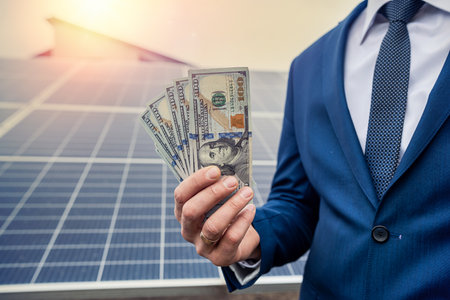 beautiful young gorgeous worker hands holding round sum of money for installing solar panels. green electricity and dollars conceptの写真素材