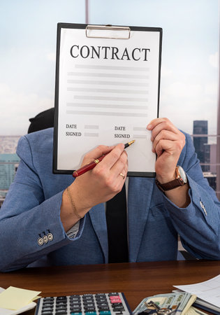 business man in a strict suit with dollars in his hands signs an important business contract. business and contract conceptの写真素材
