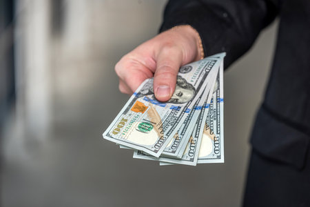 Businessman holding us dollar money in hands. saving and finance conceptの写真素材