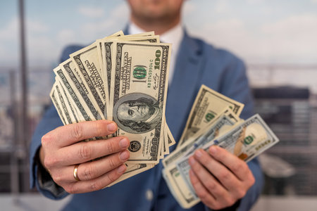 Man in blue suit count stack of dollar bills. business conceptの写真素材