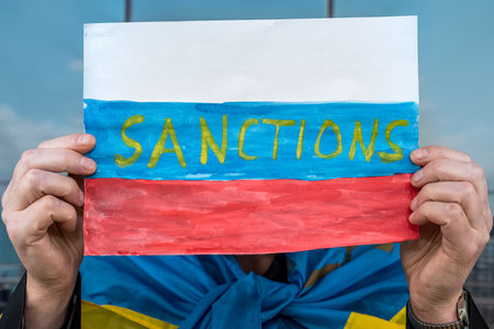 Ukraine man holding poster with message economic sanctions for Russia. the collapse of the aggressor...
