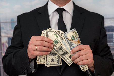 Rich man in business style counting money. Concept of success, financial flow and wealthの写真素材