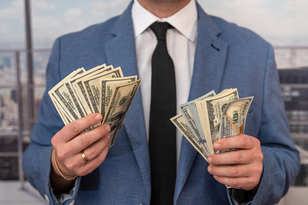 man in suit counting us money dollar, savings and finances conceptの写真素材