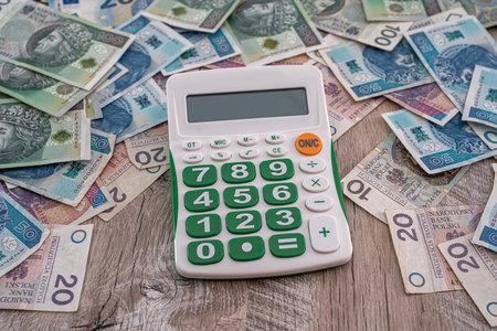 beautiful new Polish zloty banknotes beautifully scattered on the table next to the calculator. money accounting business accounting conceptの写真素材