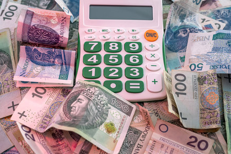 beautiful new Polish zloty banknotes beautifully scattered on the table next to the calculator. money accounting business accounting conceptの写真素材