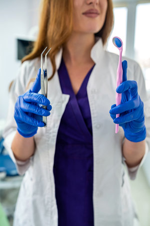 portrait of friendly happy female dentist in uniform and waiting patient at modern clinic. healthcareの写真素材