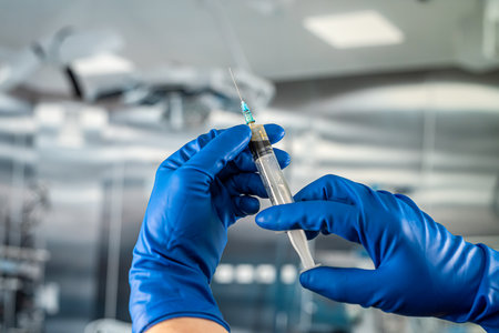 hands of medical assistant wear gloves and preparing syringe for inject anesthesia preparing for surgery in the surgical office at the hospitalの写真素材