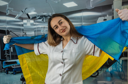 Pretty female surgeon or nurse poses and supports peoples in the Ukrainian flag during the war with Russia. global support for Ukraineの写真素材