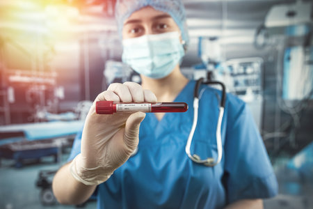 attractive experienced doctor wearing uniform facial mask protection gloves doing analysis blood probes patients at operating room in hospitalの写真素材