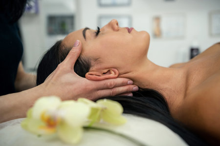 Attractive young woman is lying and receiving facial massage spa treatment. health care conceptの写真素材