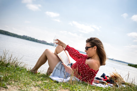 beautiful woman sitting near the lake, summer day. lifestyle relaxの写真素材