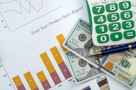 documents with graphs and diagrams and pen calculator us dollar on deks as financial conceptの写真素材