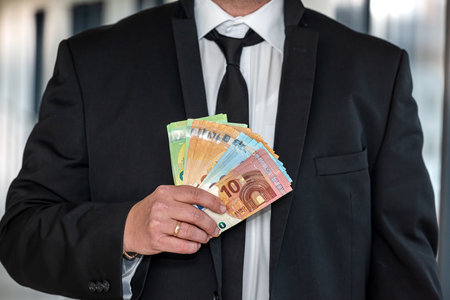 Business man wearing suit giving euro banknotes to subordinate office. concept of finance profits in a large companyの写真素材