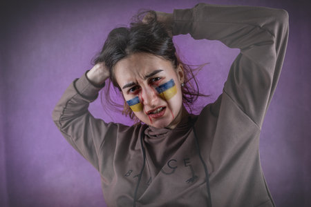 Portrait of a Ukrainian woman with a flag on the cheek sadness longing for hope of peace, war against russiaの写真素材
