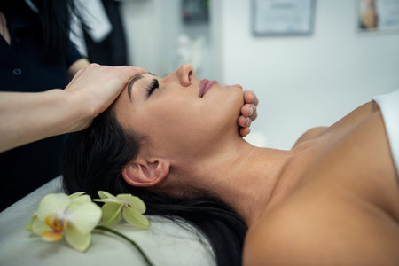 close up of beautician hands doing relaxing rejuvenating massage female client at spa salon. health lifestyleの写真素材