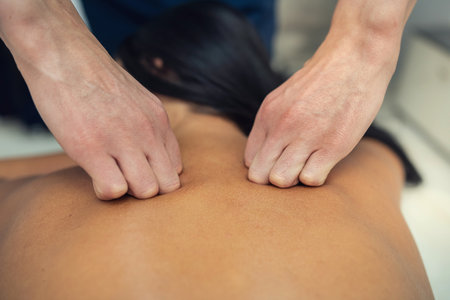 Masseur doing young woman client massage on the back and shoulders in the spa salon. body care conceptの写真素材