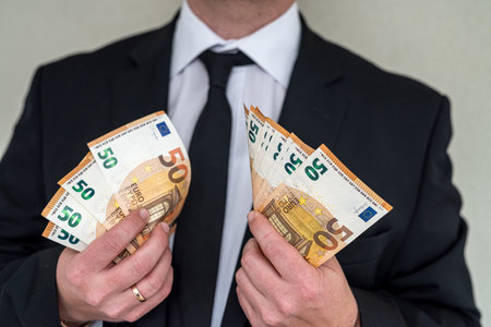 man in suit with good taste holds euro banknotes for big purchases. Big purchase conceptの写真素材