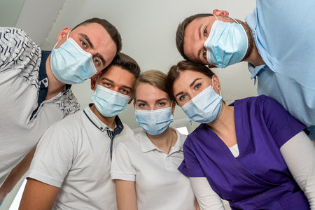 Group of dentists holding medical instruments and stant in a circle at a meeting. Patient hospitalの写真素材