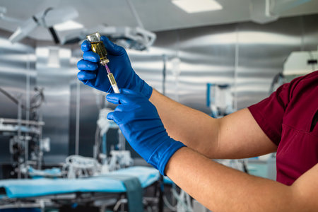 Doctor's hand in blue gloves hold medicine vaccine or anesthesia vial bottle and syringe preparing...