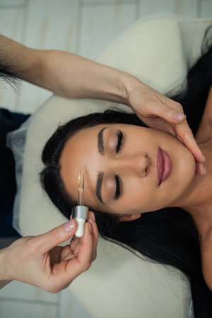 close up of drop of oil restore on woman client is lying and waiting for a massage in the background. health lifestyleの写真素材