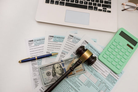 1040 individual tax form with gavel and dollars bills on desk, annual reportの写真素材