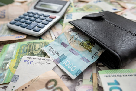 exchange of US dollars to Ukrainian hryvnias on the table with a calculator. Exchange rate conceptの写真素材